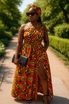 Woman in a kente african print colorful patterned dress walking outdoors on a sunny day.